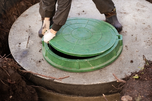 A,worker,installs,a,sewer,manhole,on,a,septic,tank