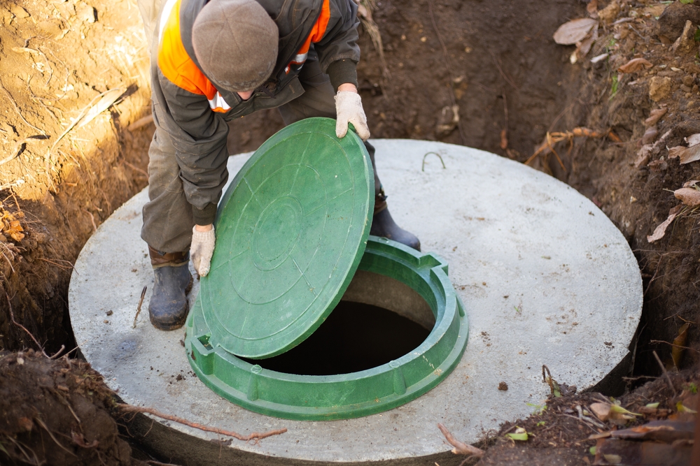 A,worker,installs,a,sewer,manhole,on,a,septic,tank