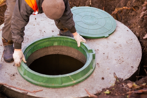 The,builder,installs,a,manhole,on,a,concrete,sewer,well.